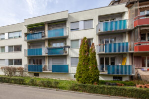 Riedmattstrasse10 strassenseitig, zwei Reihen blauer Balkone sind zu sehen