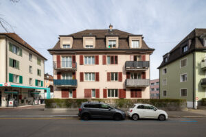 Talwiesenstrasse 170 strassenseitig, frontal fotografiert. Zwei Autos sind vor dem Haus geparkt.